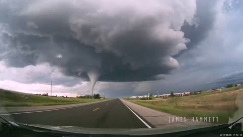 Storm chasing dashcam: Tornado crossing the highway! Laramie, Wyoming