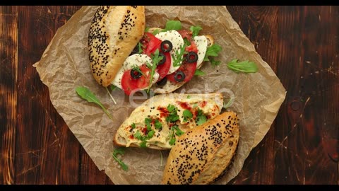 Two Delicious Sandwiches with Hummus, Tomato, Mozarella Cheese, Herbs and Olives