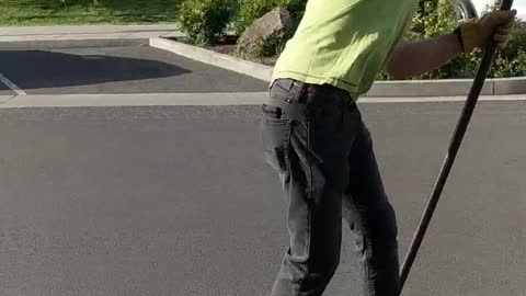 Guy green shirt rowing down street on longboard skateboard