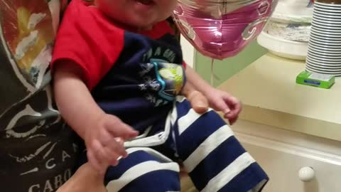 Baby giggles when sister hits a balloon