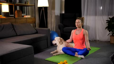 Woman doing Yoga with her pet dog