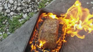 Cooking beef roast on pan off of grill on floor