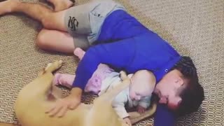 Dad, dog & baby preciously cuddle together