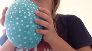 Blonde girl blue balloon sucks in helium falls backwards