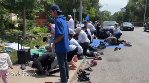 Uyghur Muslims do their afternoon prayers outside of the Chinese Consulate in Toronto