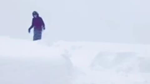 Kid sleds off snowy roof top and falls into pile of snow