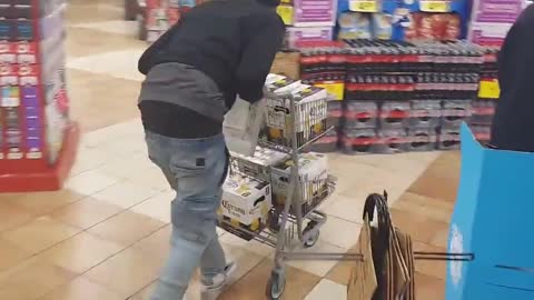 A homeless Seattle man walks out of a store with a loaded cart full of beer without paying