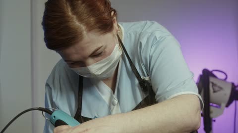 A lady is trimming a cat's hair carefully