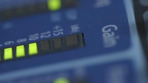 Tracking Extreme Close Up Shot of Gain Lights On Audio Mixing Board