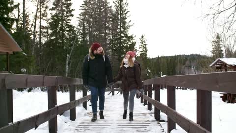 A Winter Landscape And Couple Crossing The Bridge