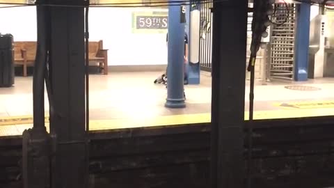 Guy in subway station does a sexy dance to r&b song uses pillar as strip pole