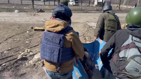 Des journalistes russes portent cette dame âgée tombée par terre