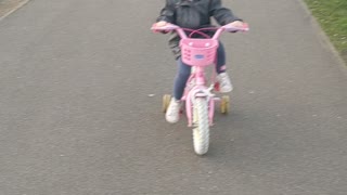 Cute toddler learns to ride her bicycle