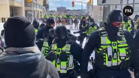 police advancing on protesters thrusting guns into their bodies.