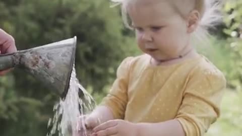 Child clearing her hand through water can - OMG cute !