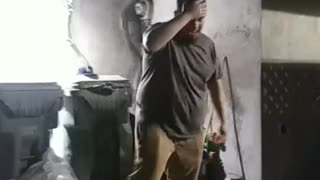 Guy in grey t-shirt tries to crack a beer on his head and drops it