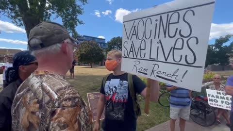 Ontario: A masked placard carrier intrudes an anti covid tyranny demonstration..