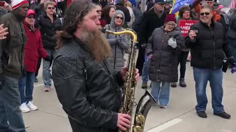 Saxophonist Plays National anthem in street during Milwaukee protest
