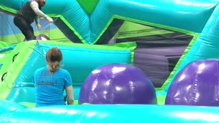 Grown man trampoline obstacle course slips on purple ball