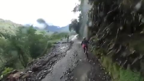 Are they not afraid of danger when riding bicycles on this cliff road?