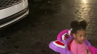 Adorable Toddler wants to park her toy car in her mum's garage