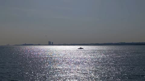 Sunlight reflection on the sea with a beautiful scenic view, passing ships and calm music