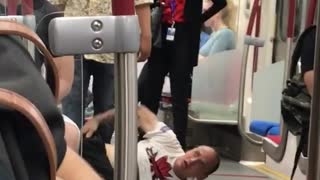 Homeless man on subway train on the floor getting kicked out