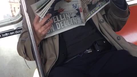 Old man sings opera and reads newspaper on subway train