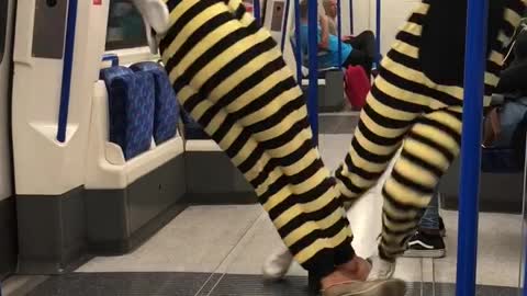 Couple yellow bee costume subway blue pole spin