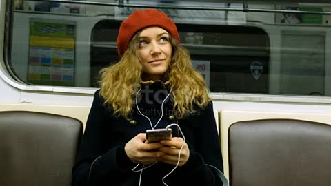 Beautiful woman with headphones using the phone in a subway stock video