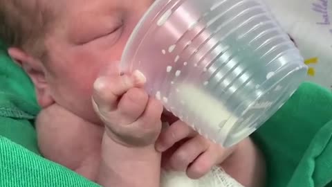 2-days-old baby drinking milk himself