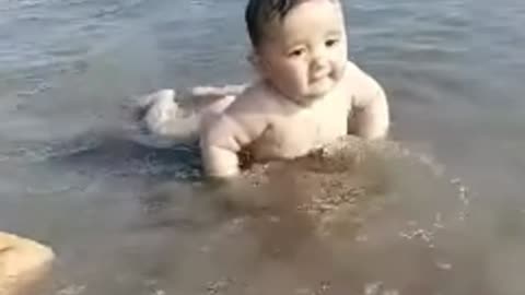 Cute Baby Playing Water In The Sea Beach.