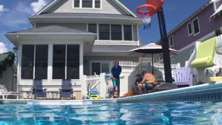 Talented kid scores a perfect slam dunk while jumping into pool