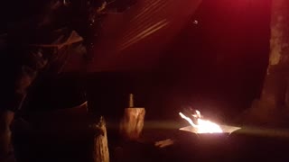 Preparing the campfire in the portable firepit for a campfire vlog under a tarp. In the rain