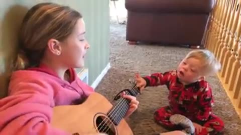 Sister sings to baby Brother.