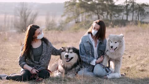 Two girls with two Husky dogs