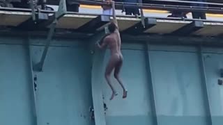 INSANE video shows naked man dangling by one arm from a 6 train station in the Bronx.