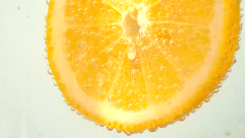 Orange slice dipped in a soda