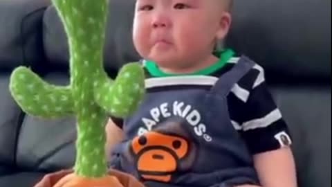 Cute babies playing with toy dancing cactus