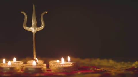 Metal Trishula Statue Divine Trident Symbol Of Hinduism On Decorated Table With Tea Lights Blown Out