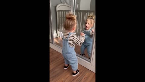 Toddler adorably dances in front of a mirro