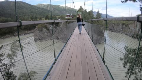 The Altai mountains, the island of Patmos. Russian girl walking on a suspension bridge