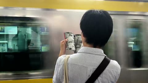 Japanese style reading Manga while waiting for the train