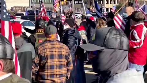 An elderly lady is pushed down by an anti Trump protestor at Stop The SteaI rally in Wauwatosa, WI