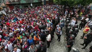 Inmigrantes hondureños pasan a la fuerza barrera policial y entran a México