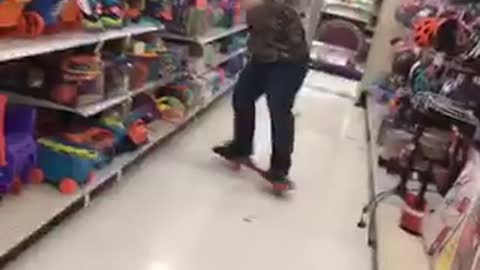 Guy in army sweater falls off red skateboard