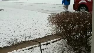 Lousy weather blue jacket guy walking down sidewalk slips on snow