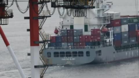 Workers moving containers from a cargo ship