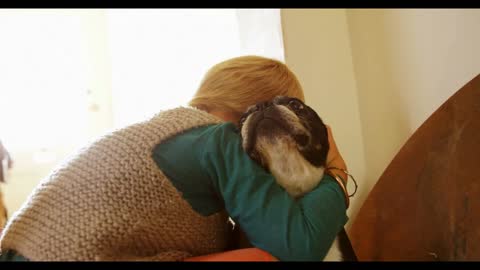 Boy embracing his pet dog at home