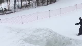 Guy snowboards off ramp and falls before jumping, mom laughs loudly